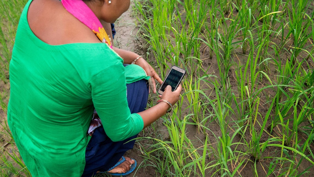 Nepalese farmer using mobile phone apps to enhance her yields and access services