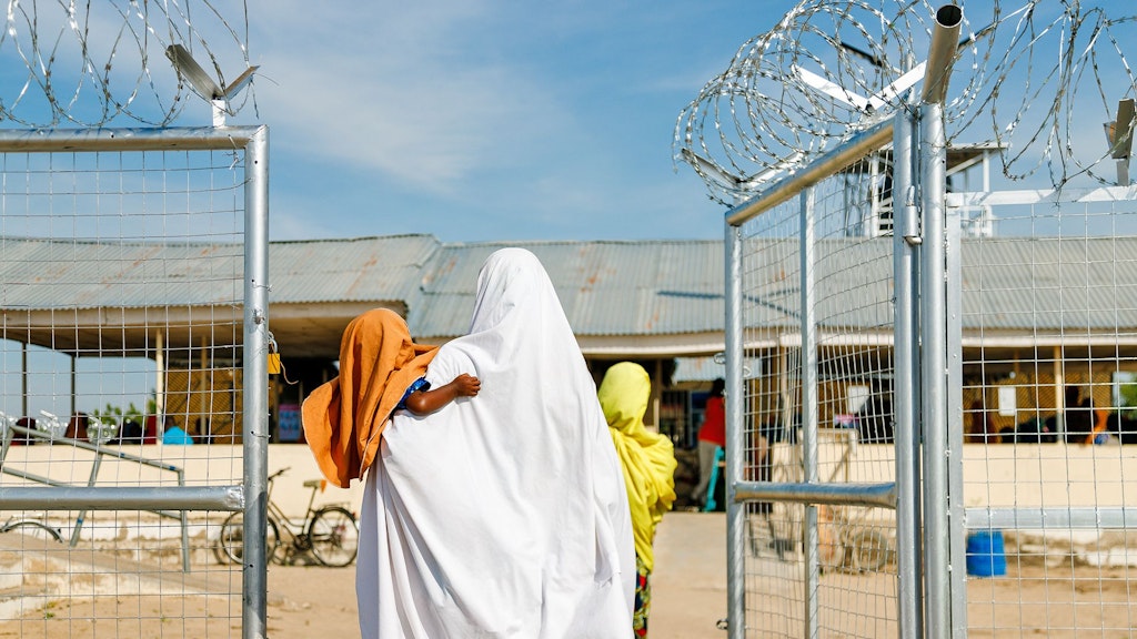 Nigeria. Bawagana (25) carrying her baby Zainab walking into a WFP supported nutrition clinic